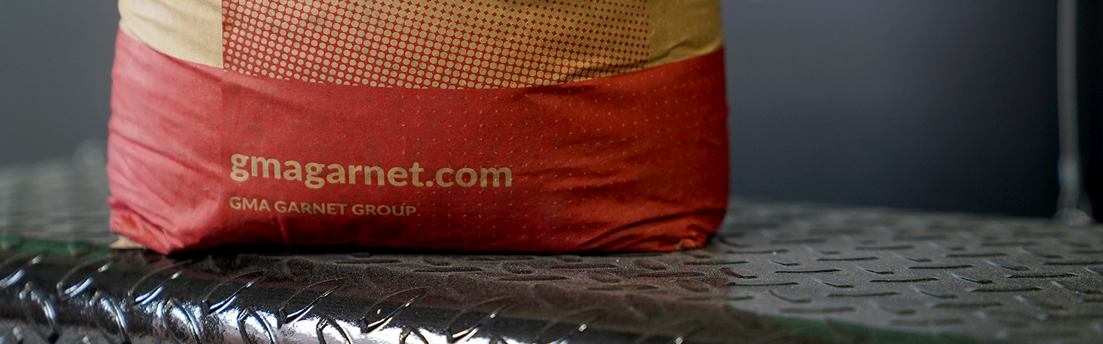 Photo: Image featuring the GMA Garnet Group logo on a bag of pyroxene media abrasive